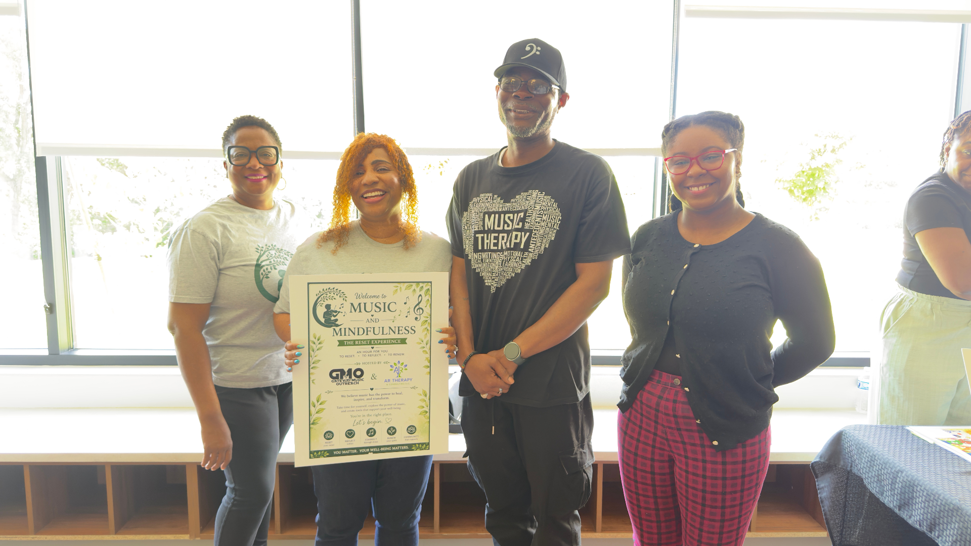 Team members holding the Welcome to Music and Mindfulness Reset Experience poster