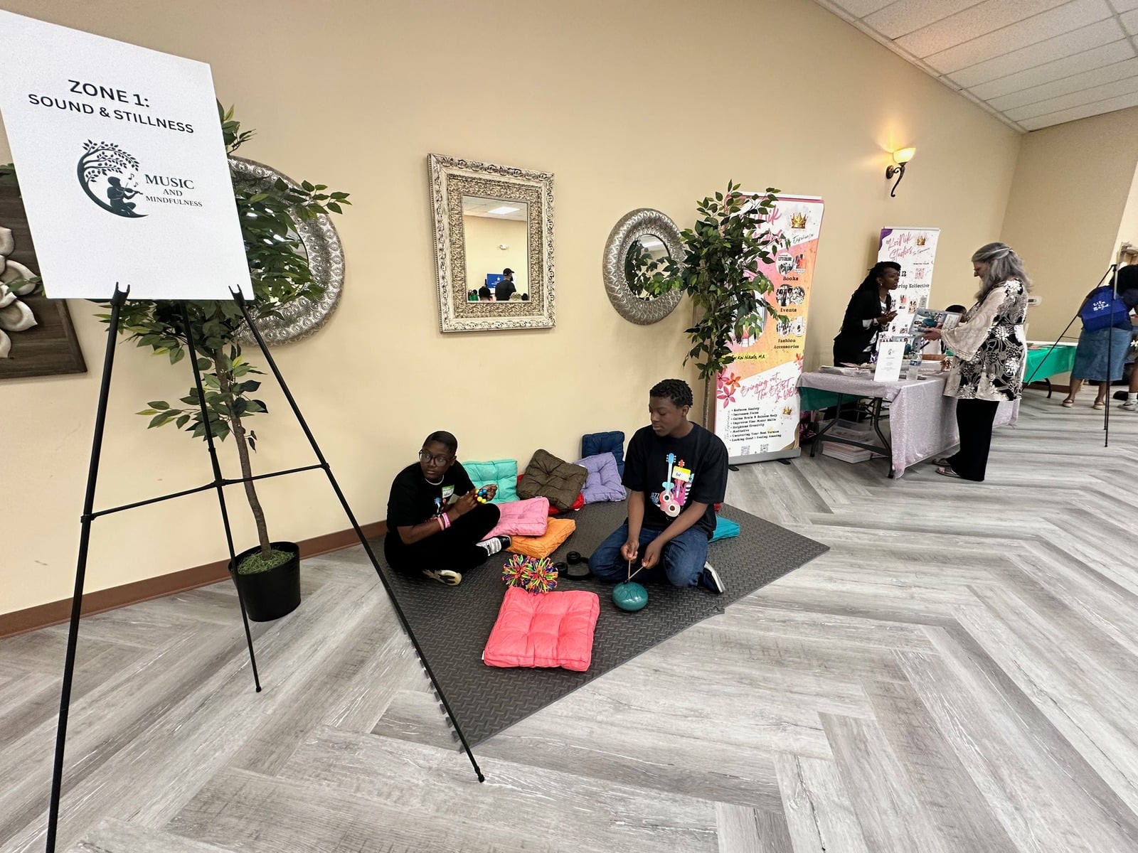 A circle of community members sitting together in a sunlit room
